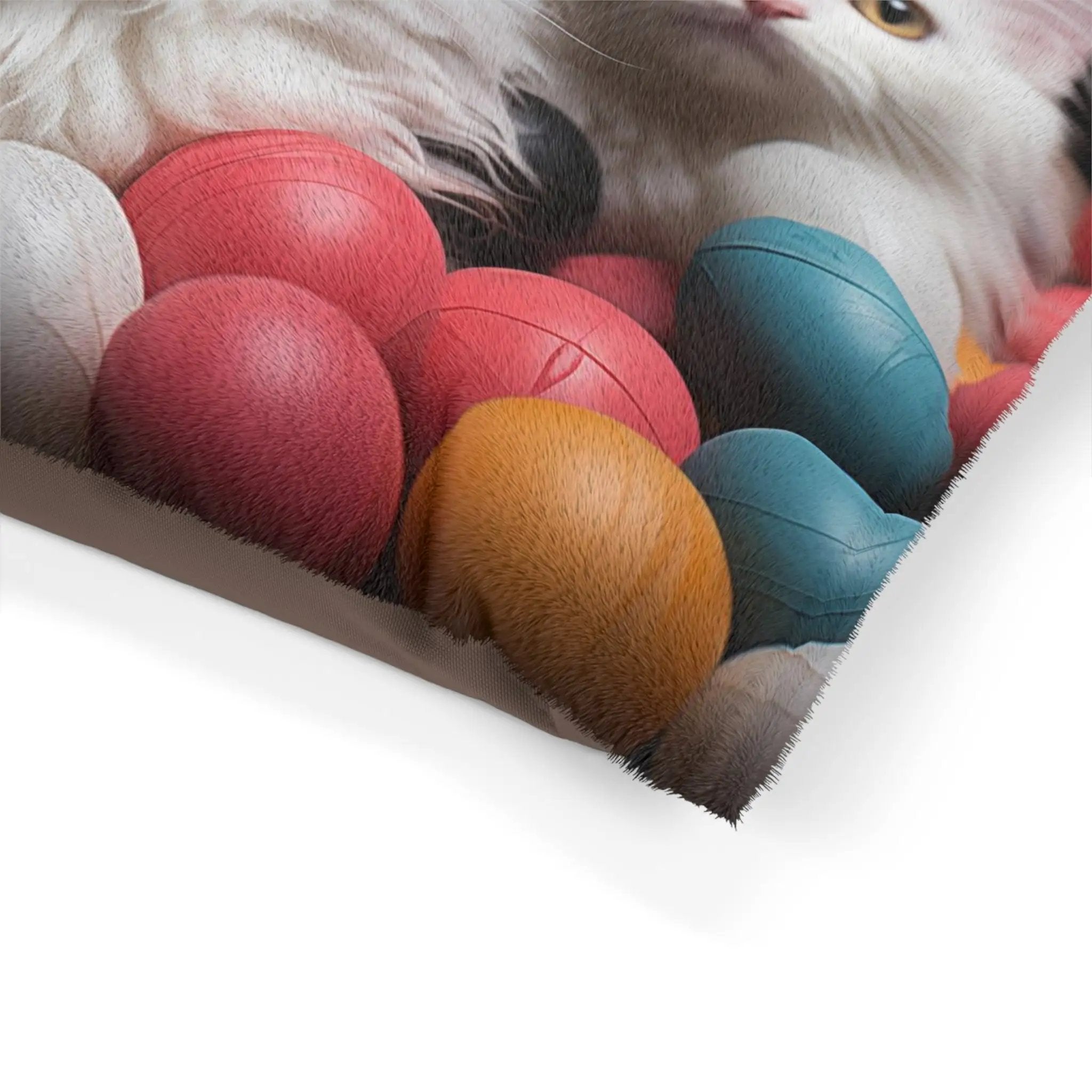 Pet Bed | a cat laying on top of a pile of balls