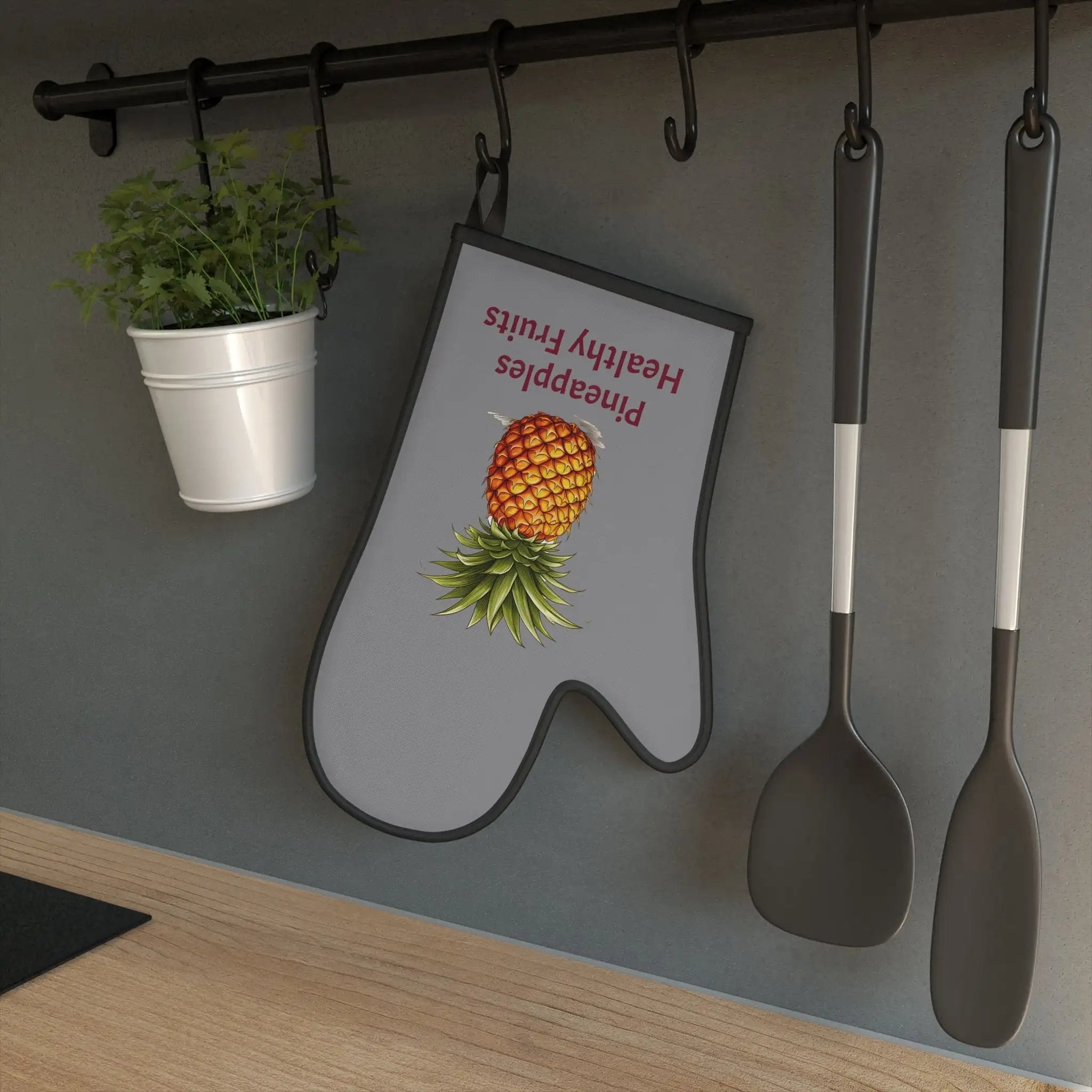 oven mitt | a kitchen with a potted plant and spoons hanging on the wall