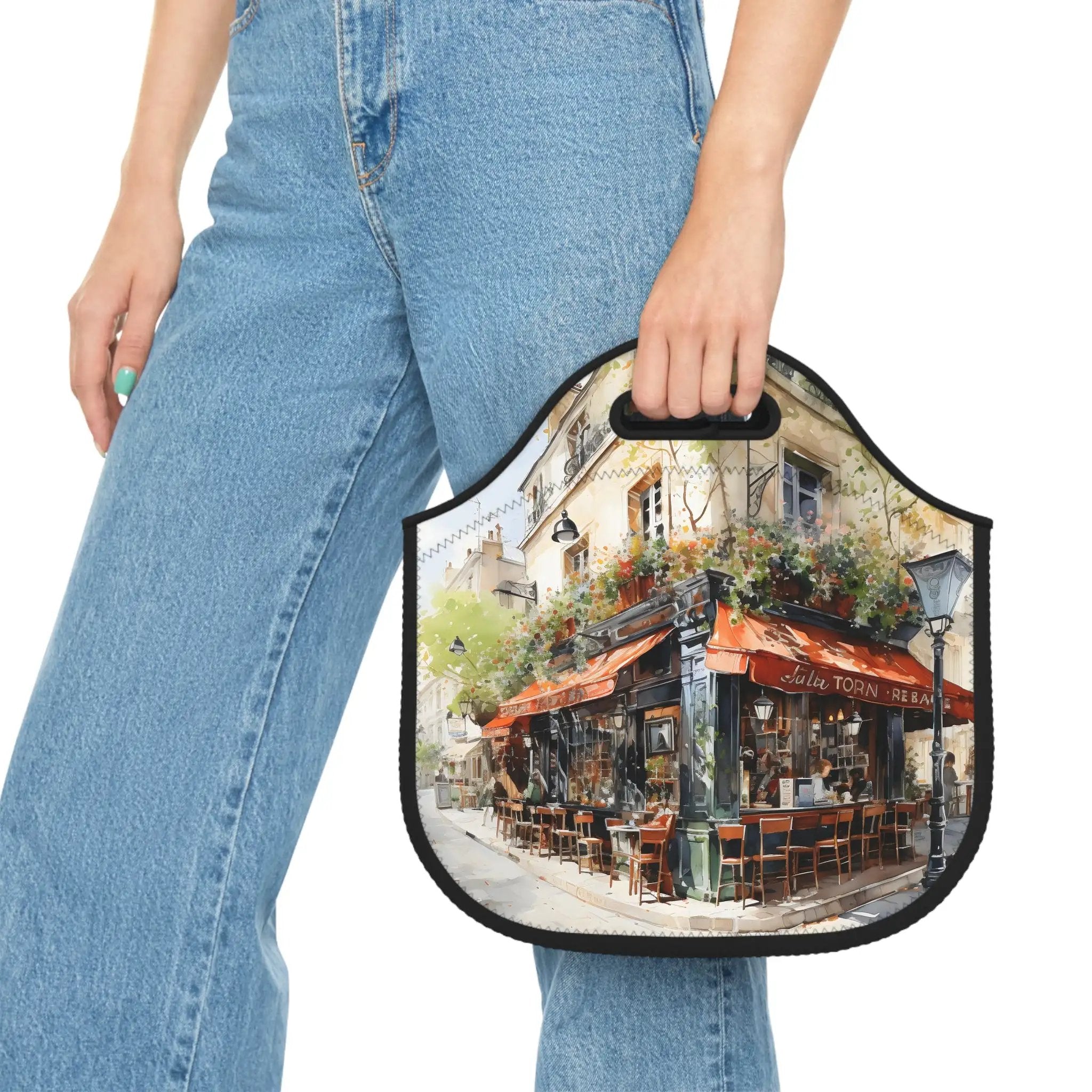 Insulated lunch bag | a woman carrying a lunch bag with a painting of a cafe