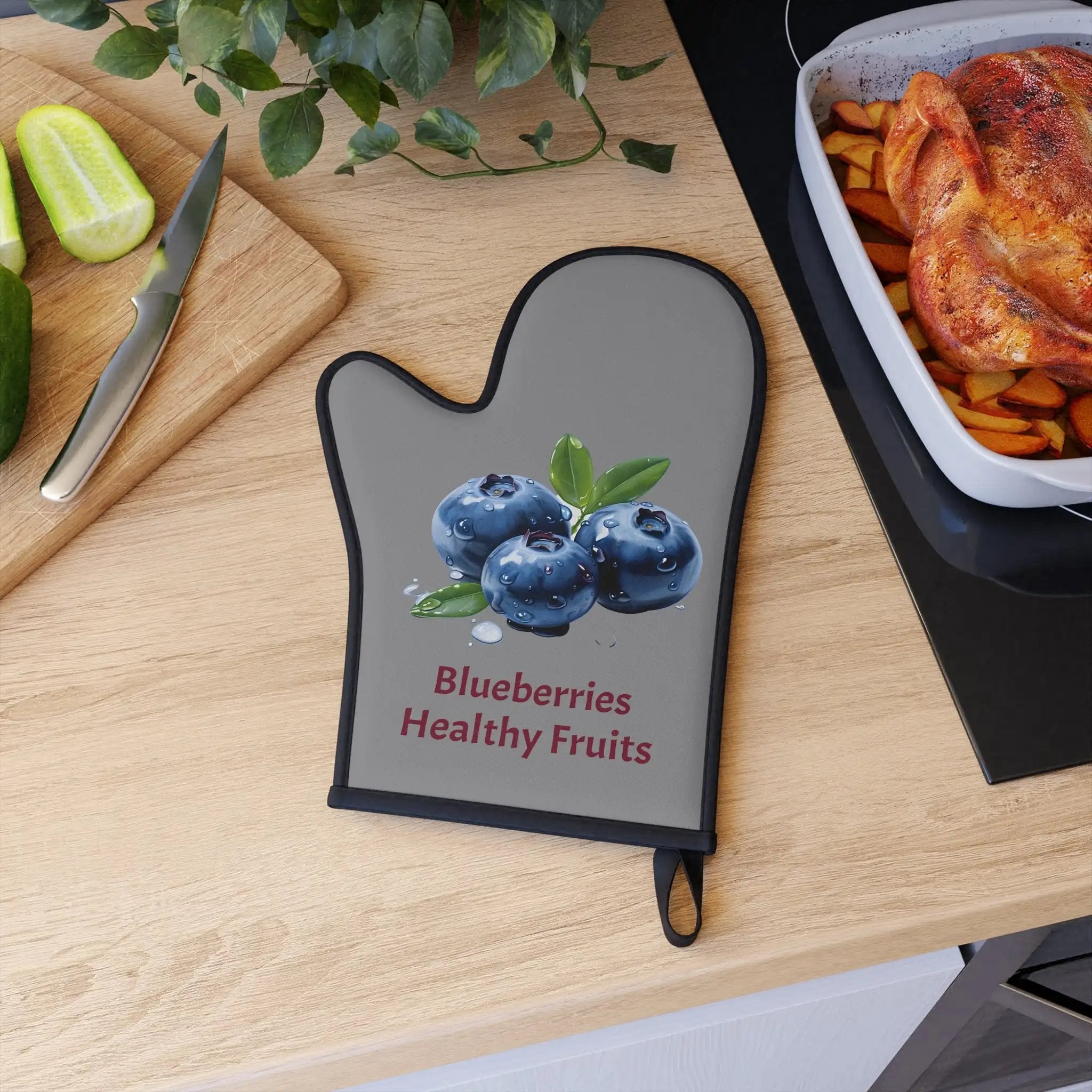 oven mitt | a wooden table topped with a cutting board and a cutting board covered in blueberries