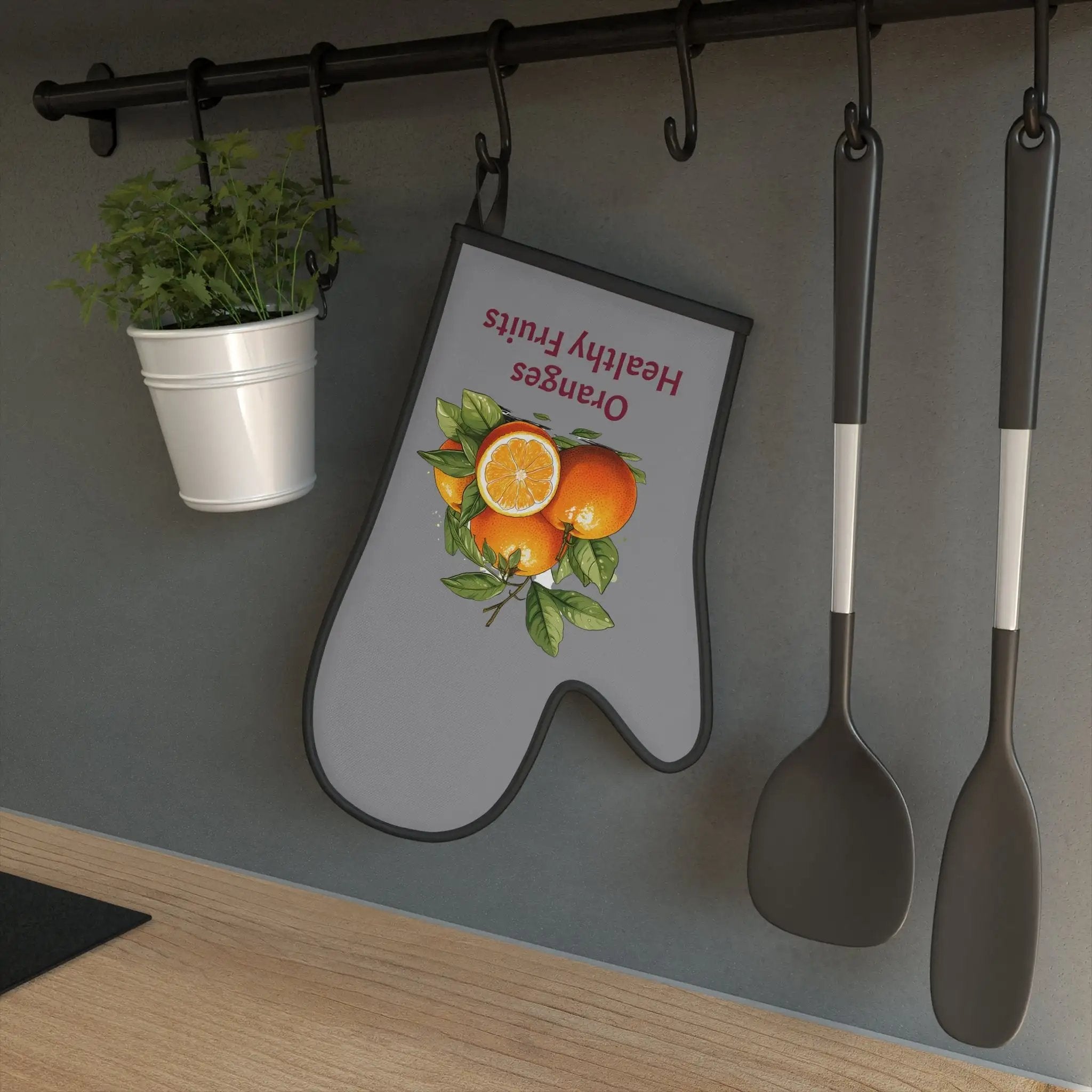 oven mitt | there is a sign on the wall with spoons and a potted plant