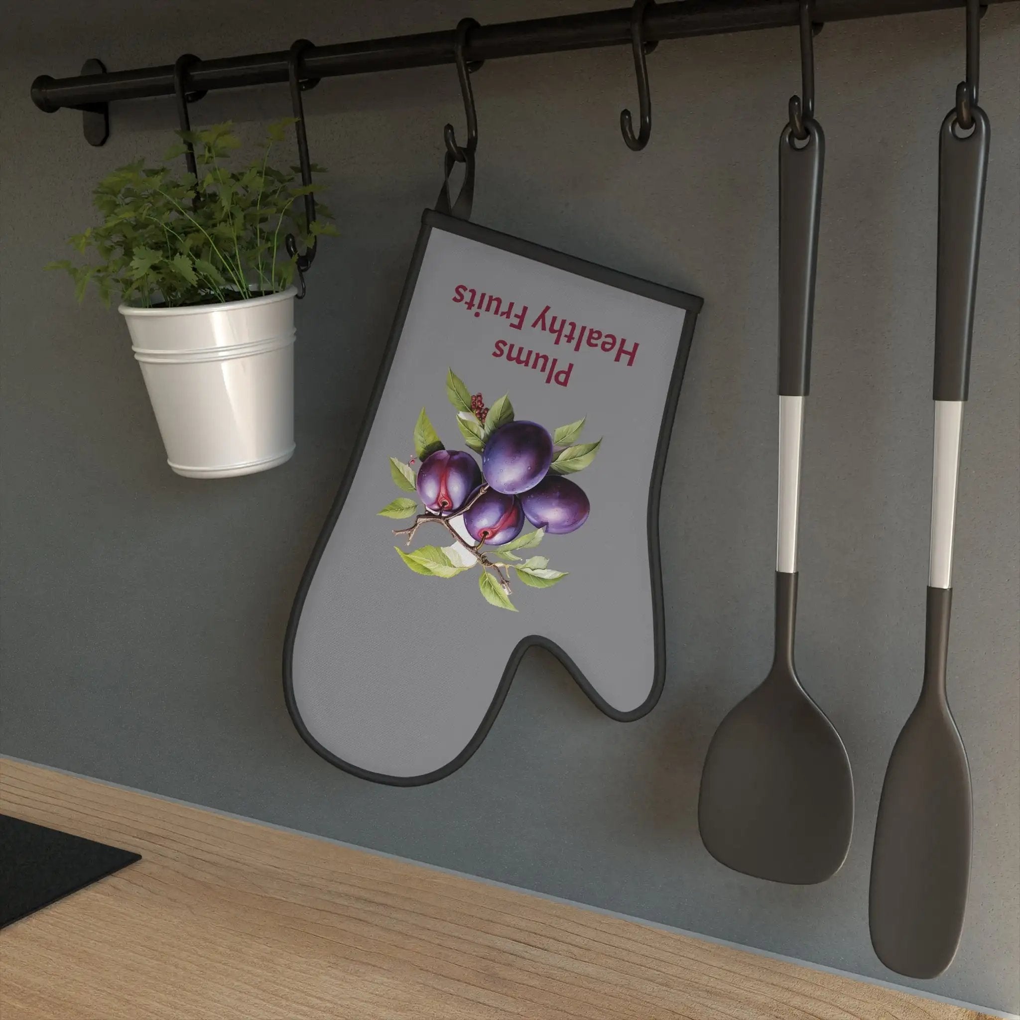 oven mitt | spoons and spatulas hanging on a wall next to a potted plant