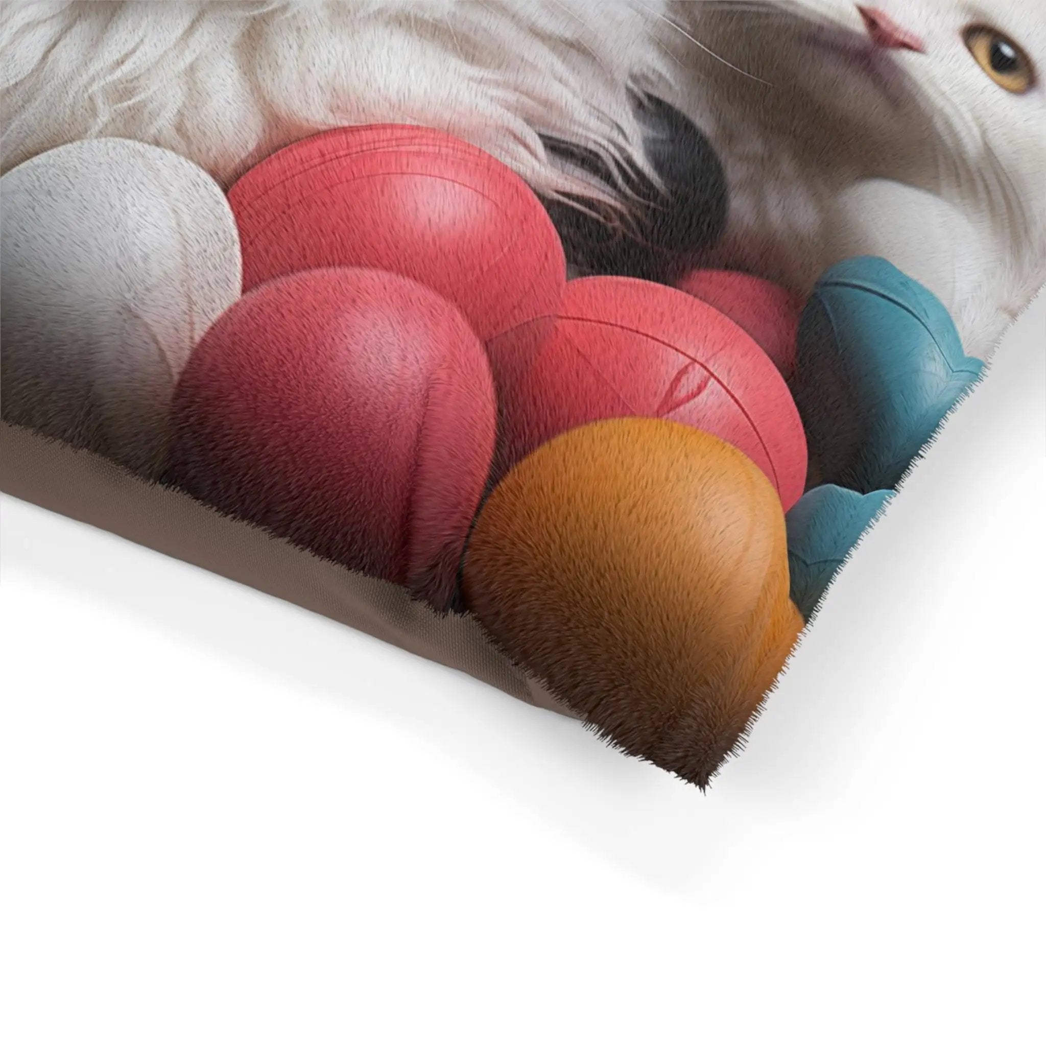 Pet Bed | a white cat laying on top of a pile of balls