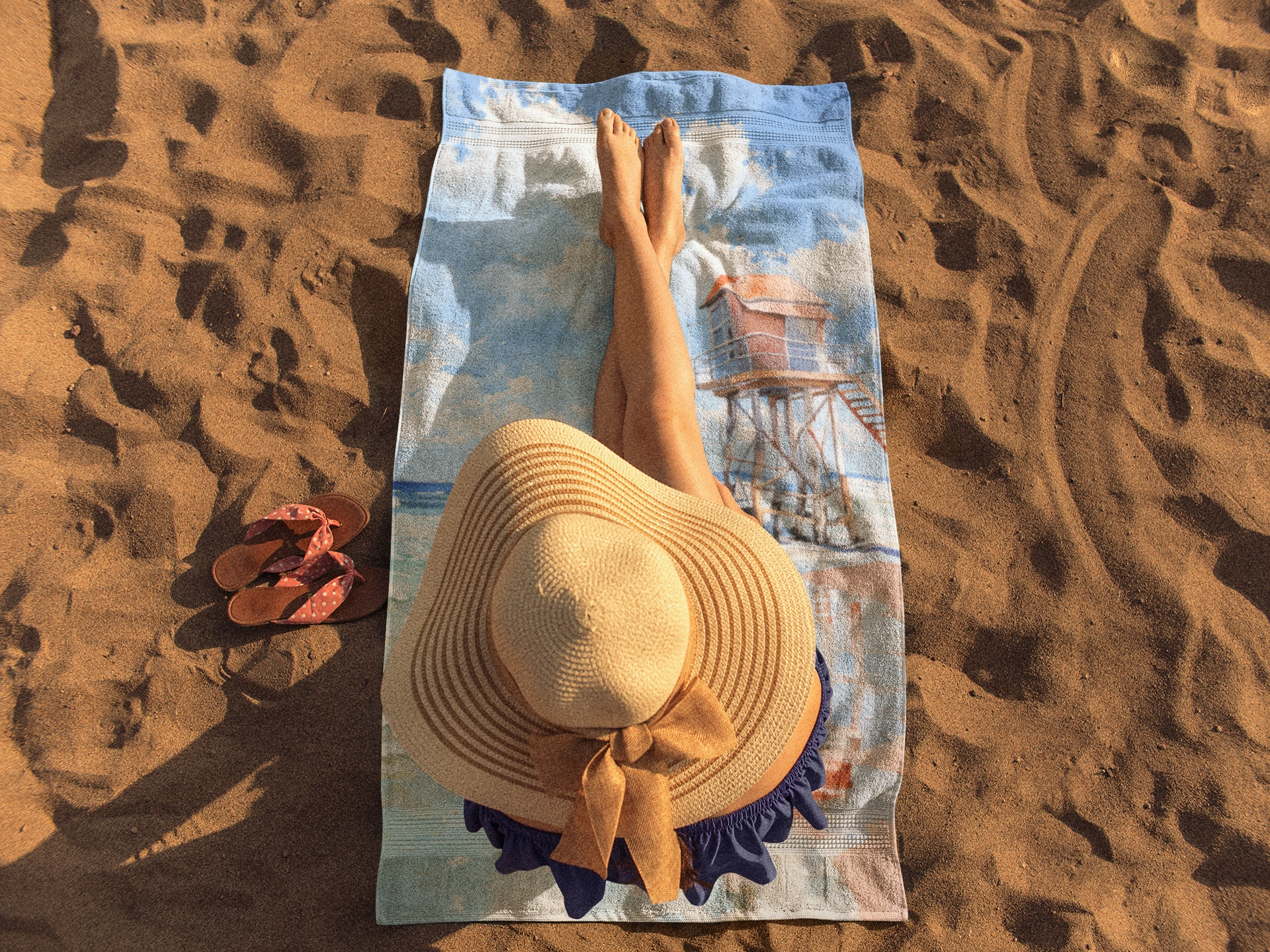 Best bath towel | a woman laying on top of a towel on top of a beach