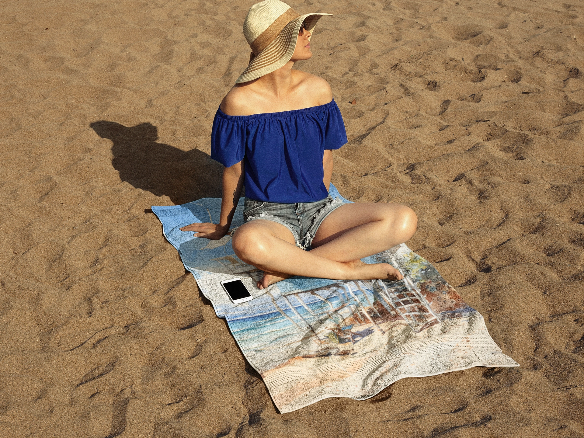 Best bath towel | a woman sitting on top of a towel on top of a beach